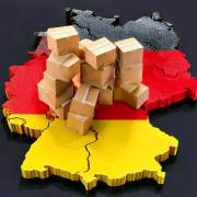 3D Illustration einer Deutschlandkarte, darauf gestapelte Pakete und ein grauer Hintergrund. Dieses Bild wurde mit KI generiert.